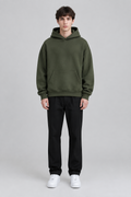 Model wearing the SAUVRIM Olive Arch hoodie, front view