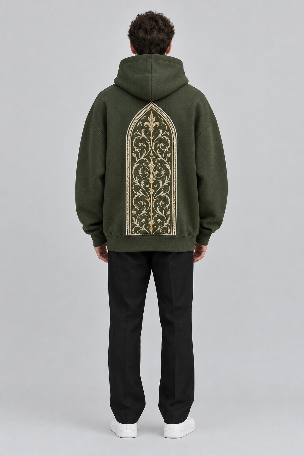 Model wearing the SAUVRIM Olive Arch hoodie, back view with the arch embroidery