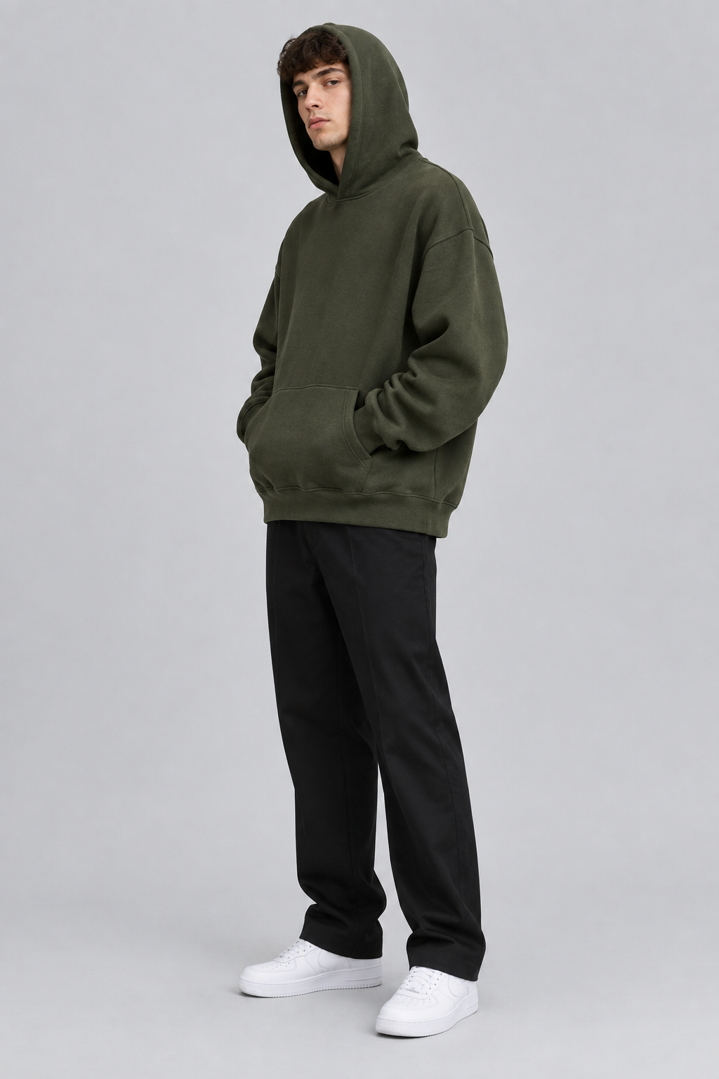 Model wearing the SAUVRIM Olive Arch hoodie with the hood up